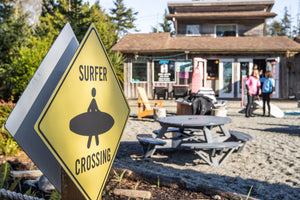 Surfer Crossing sign with a surf shop in the background