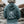 A person viewed from behind wearing a blue hoodie with a large white surf graphic and the text 'SURF SISTER, standing outdoors on rocky terrain.
